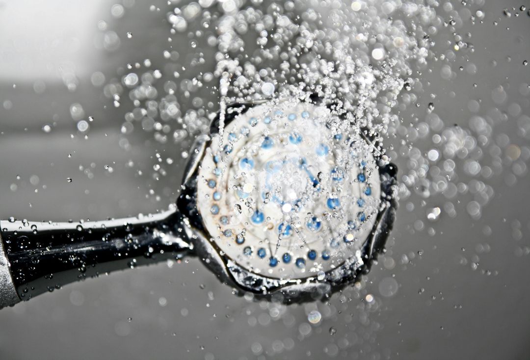 a shower head putting out hot water in a house